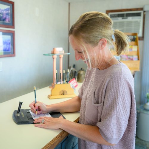 Smiling woman filling out form at Welshs Motel