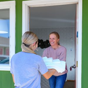 Smiling employee handing guest folded towels